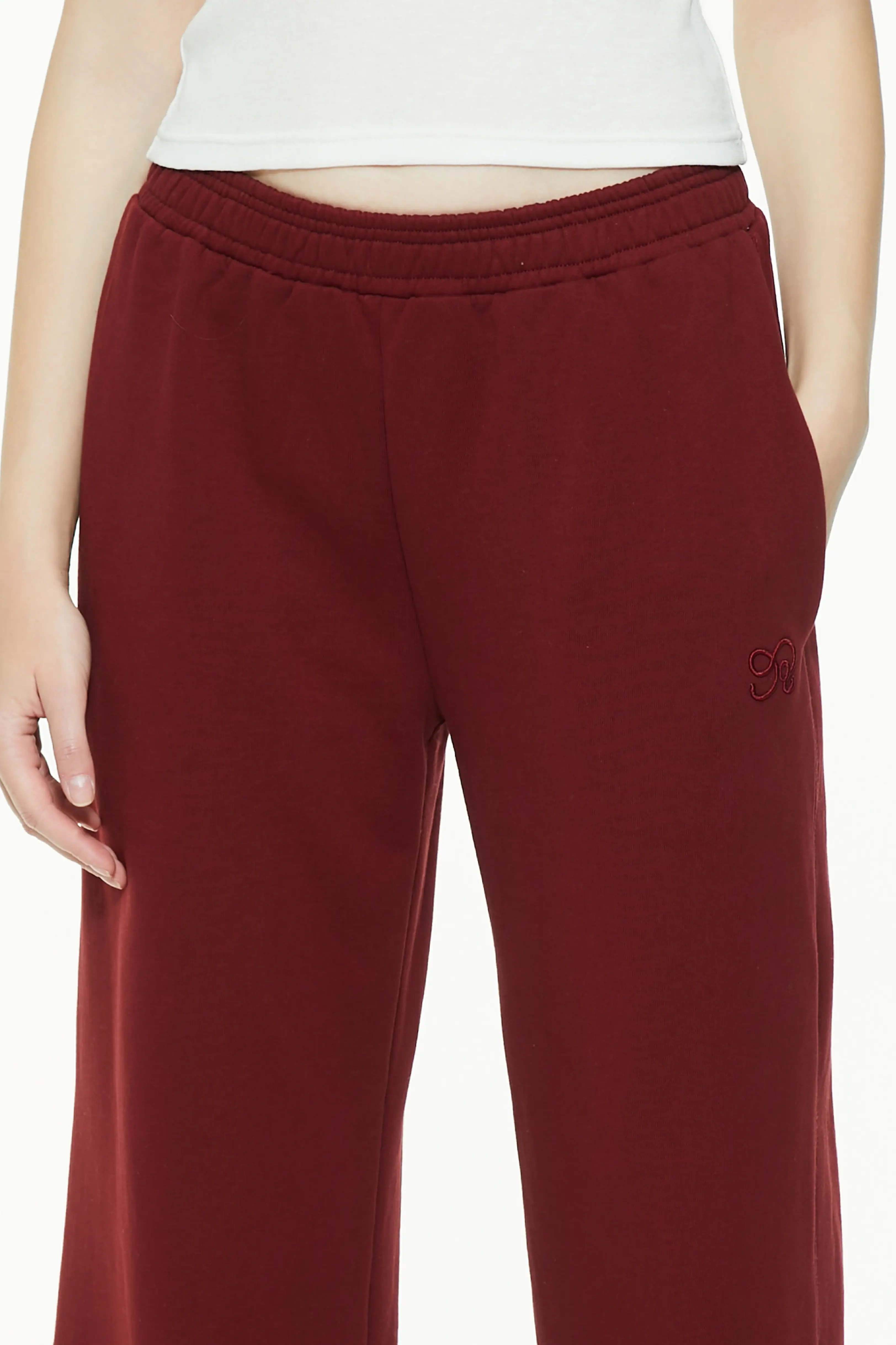 Close-up of burgundy wide leg sweatpants highlighting elastic waistband and side seam