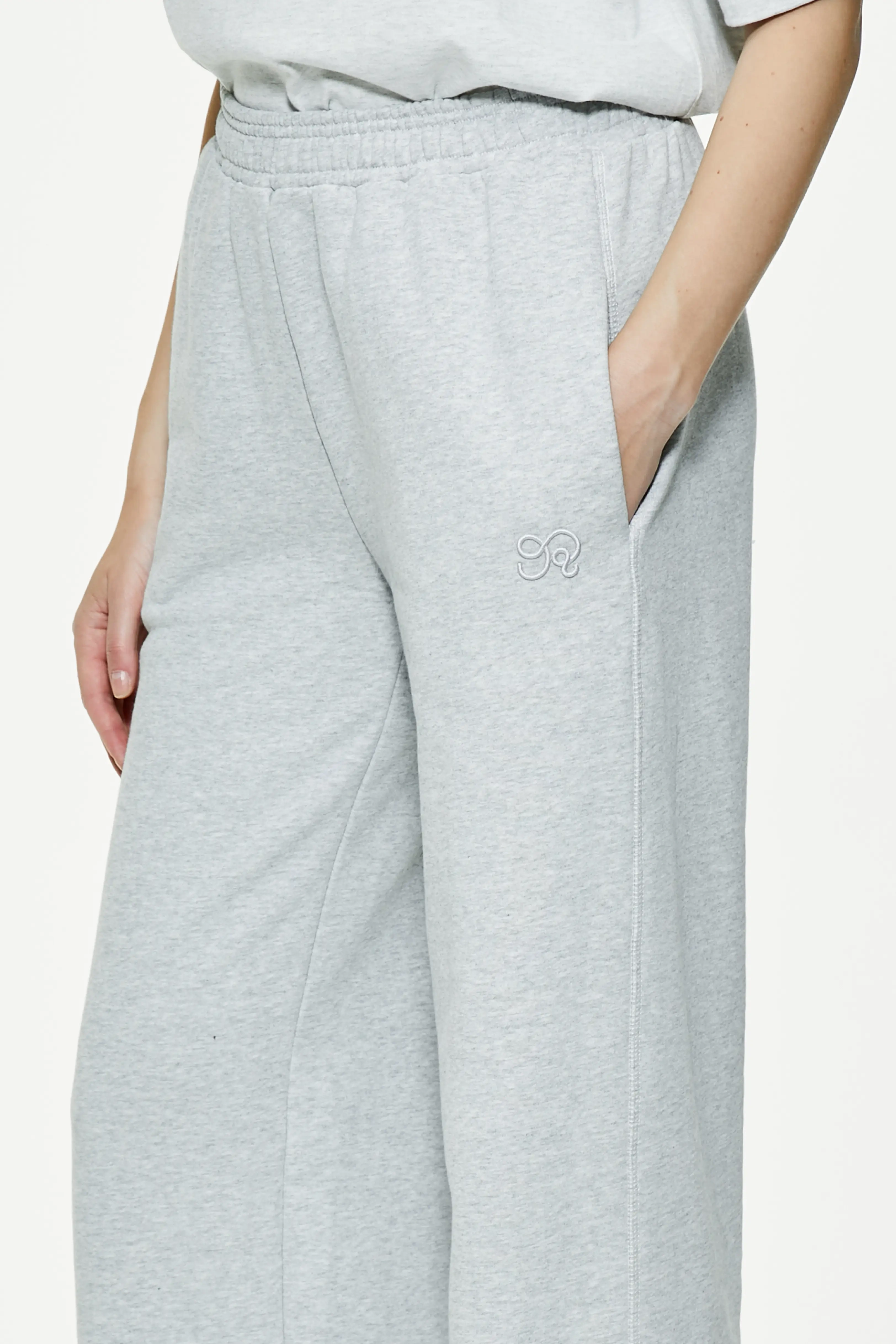 Close-up of heather gray wide leg sweatpants focusing on elastic waistband and side pocket