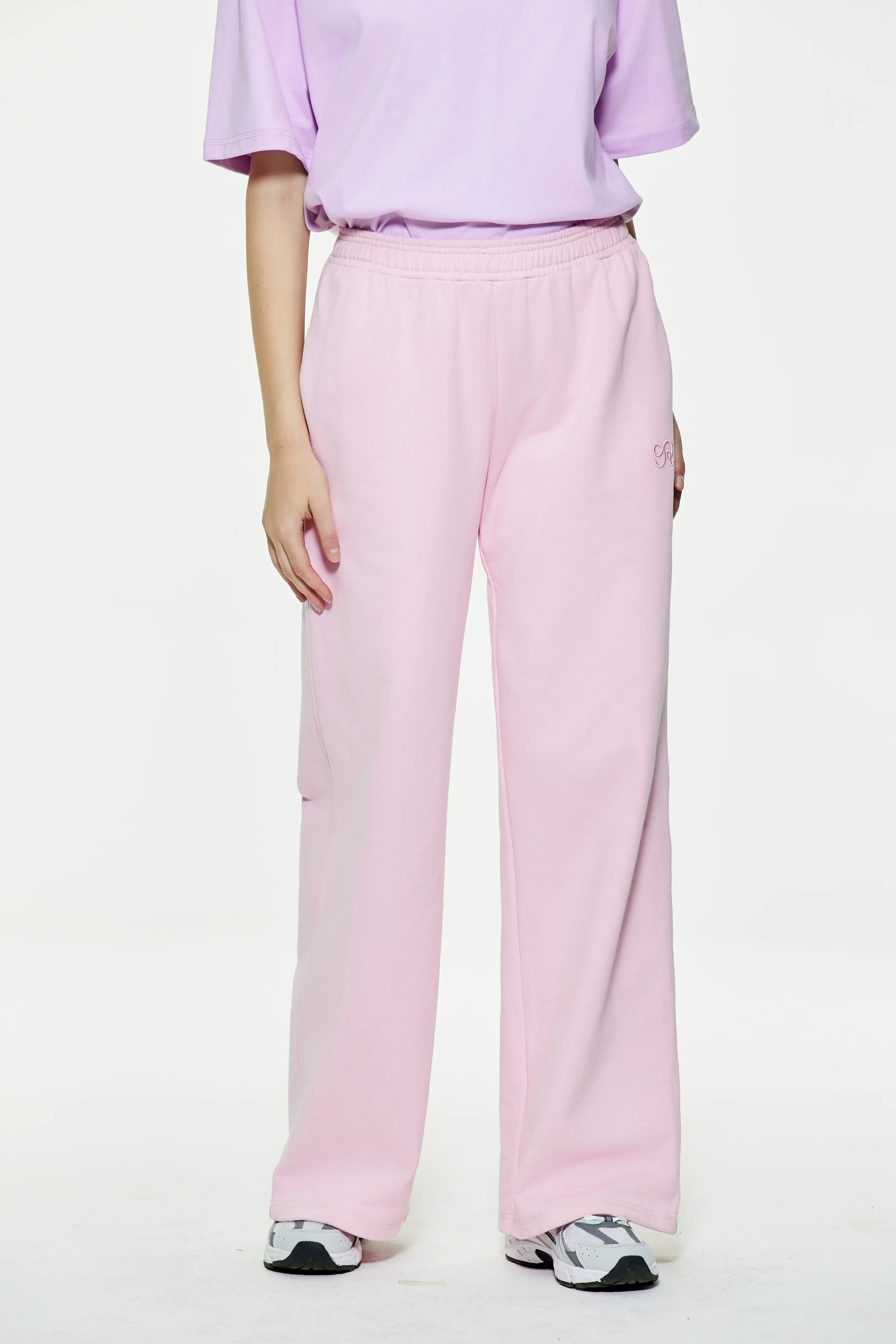 Light pink wide leg sweatpants with elastic waist and relaxed straight-leg silhouette