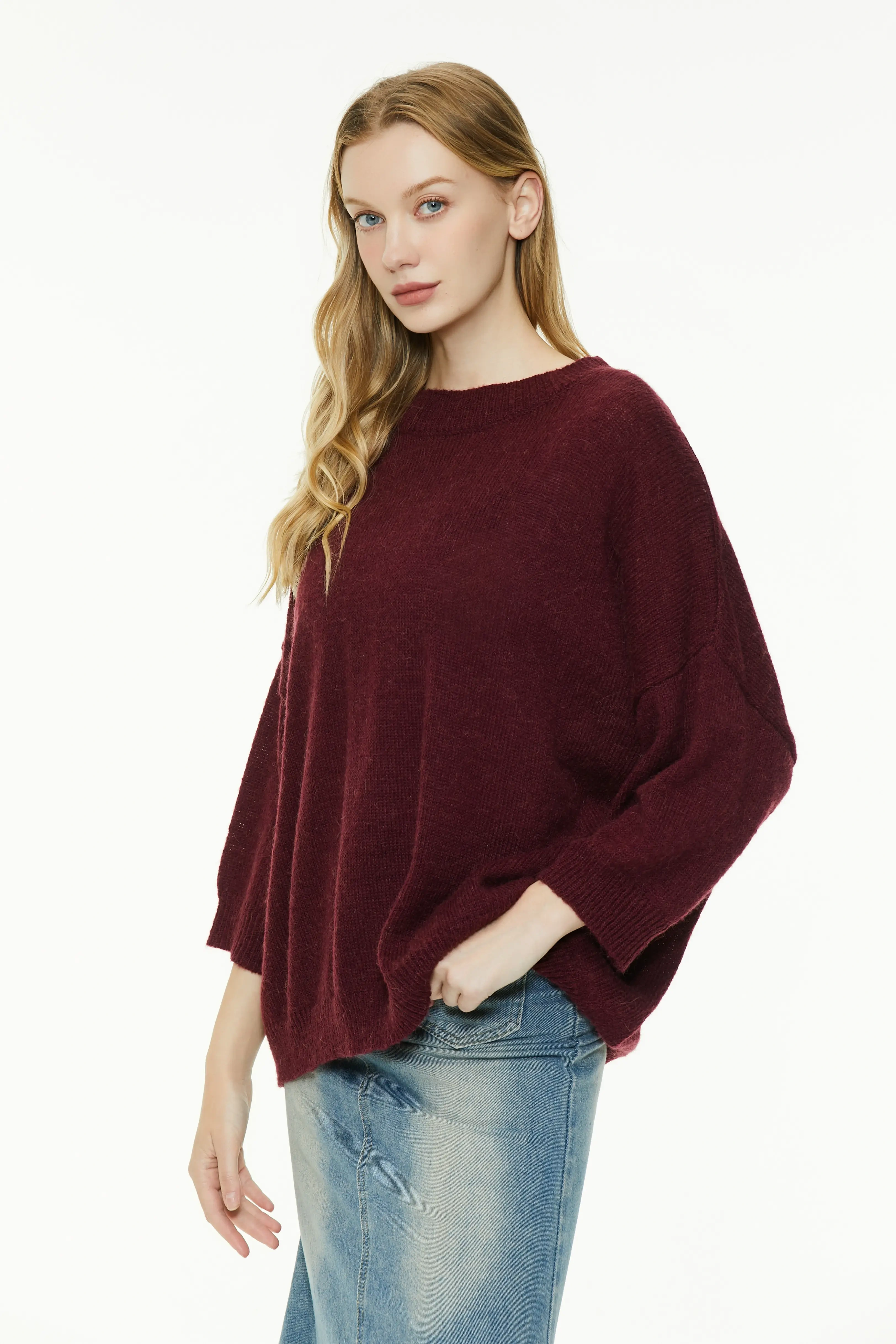 Burgundy knit sweater with loose sleeves paired with a denim skirt