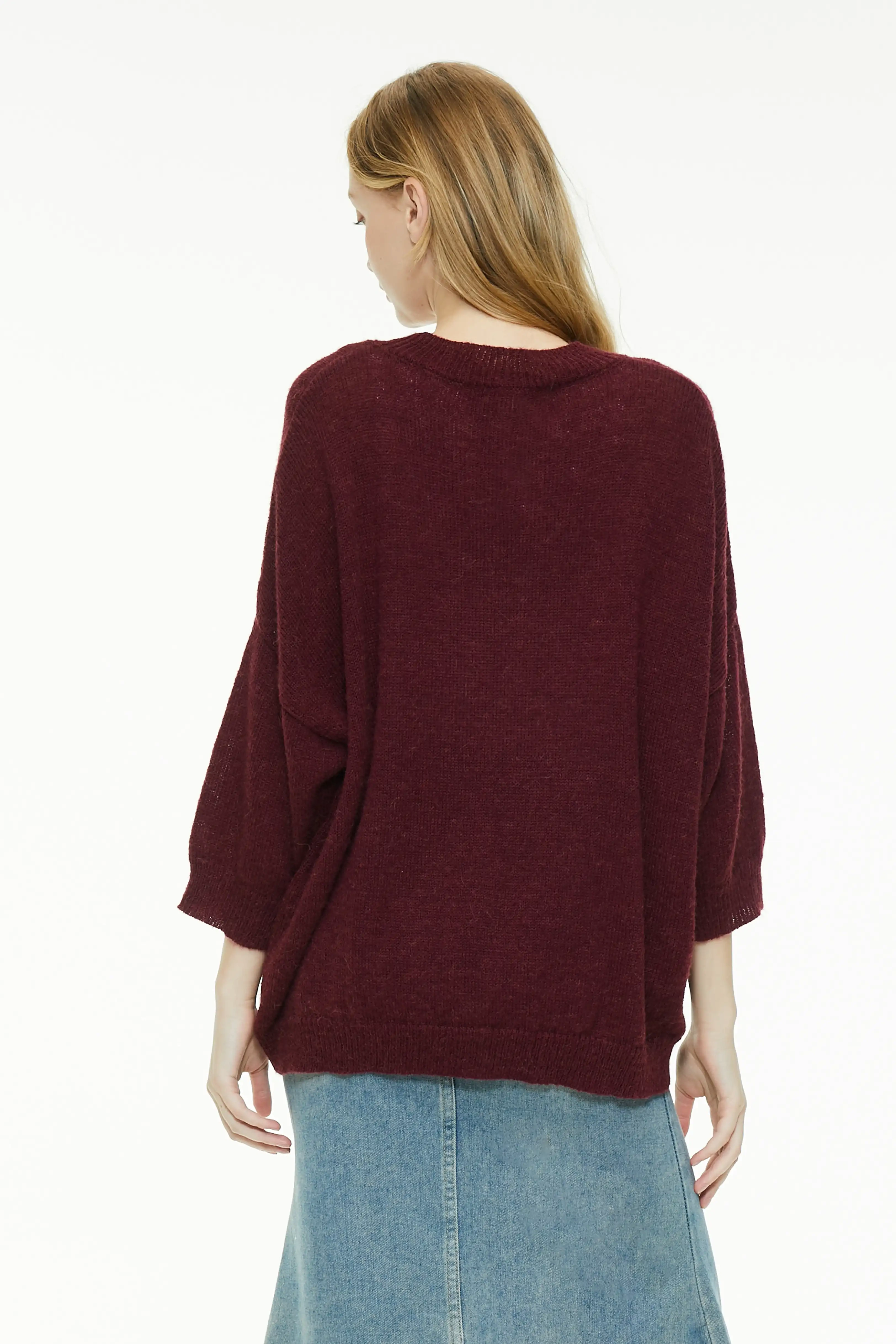 Burgundy knit sweater showing a relaxed rear drape