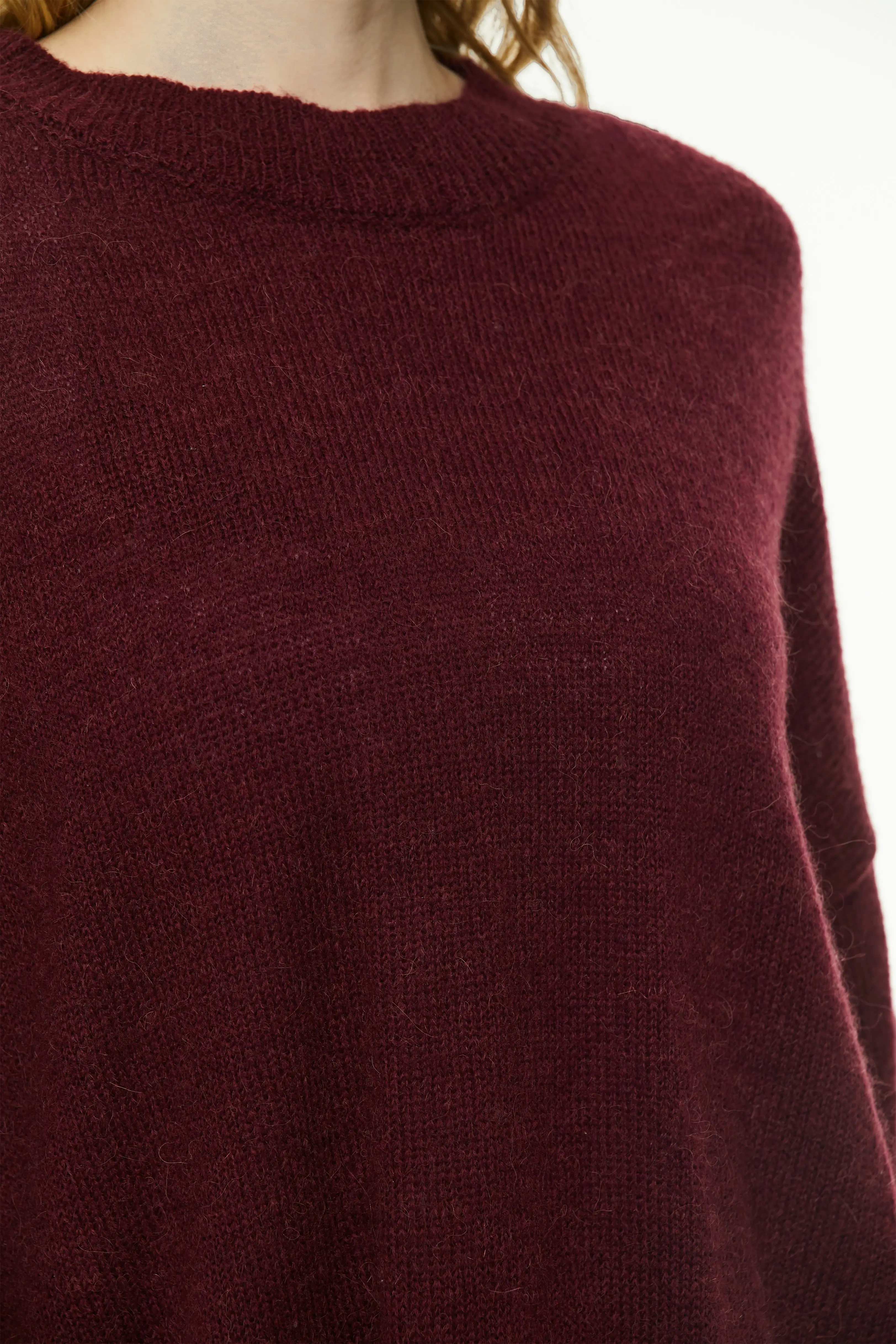 Close-up of burgundy knit sweater showing soft textured knit fabric