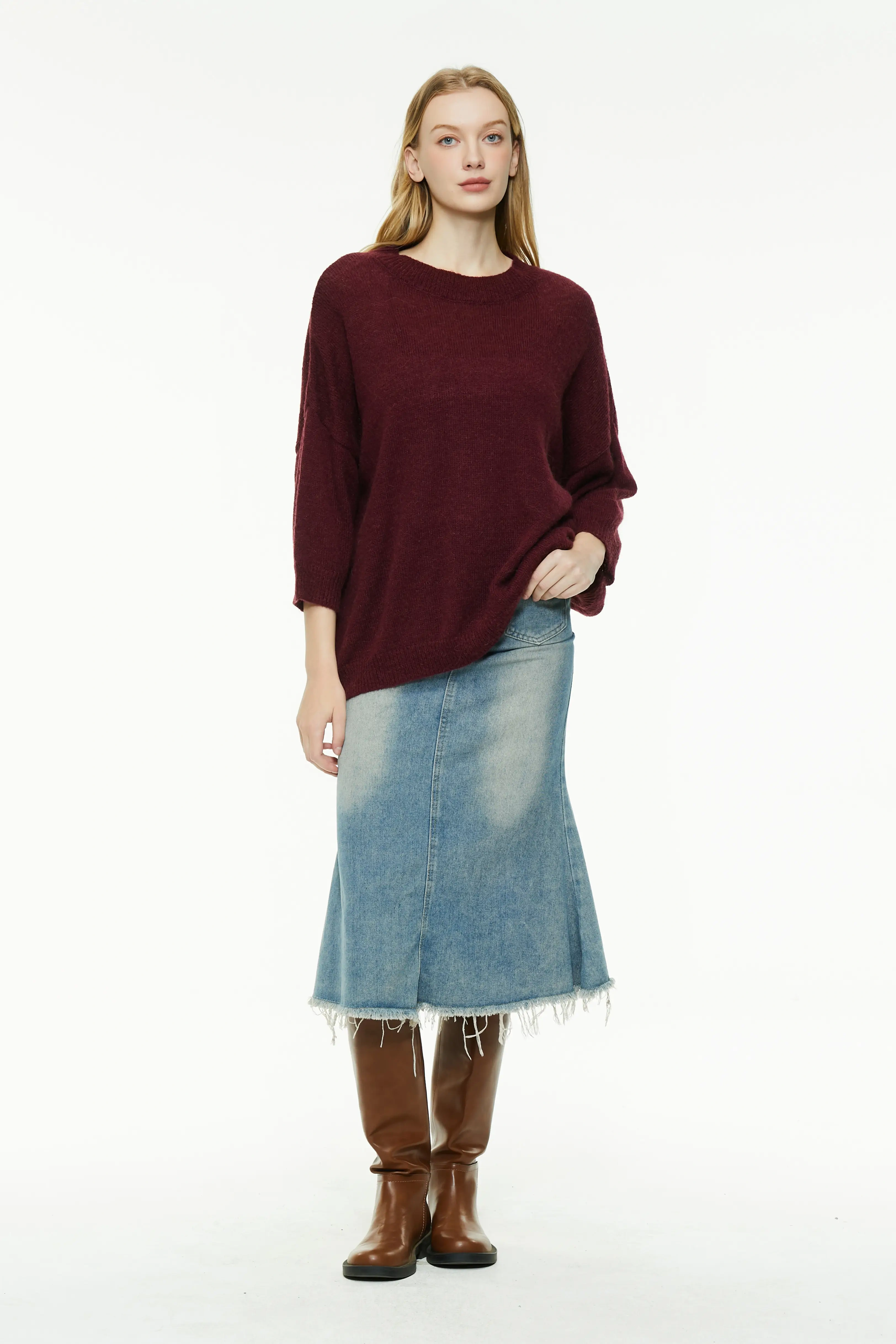 Burgundy knit sweater with a denim skirt and tall leather boots