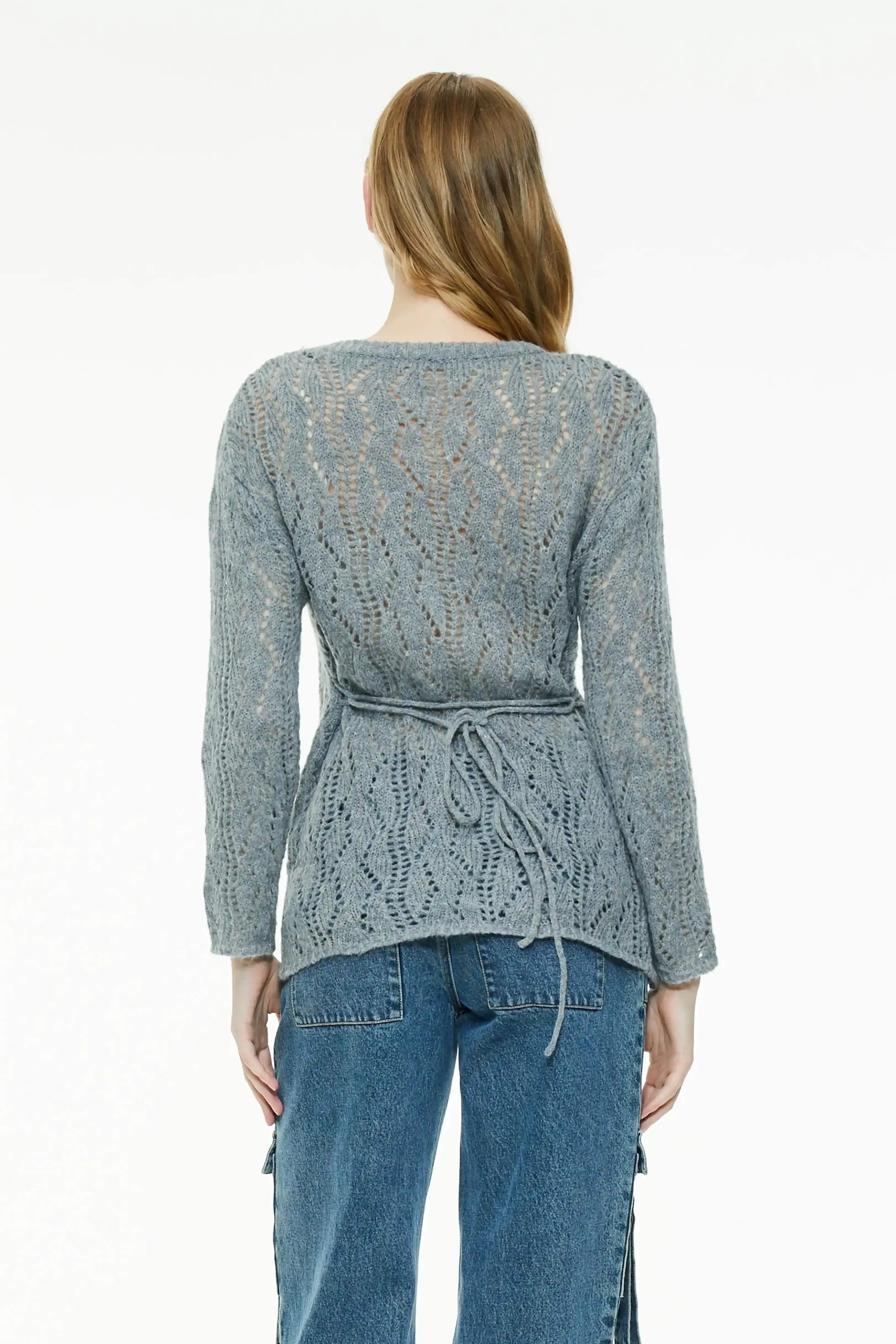 Back view of a gray sheer knit sweater showing a cinched waist tie detail