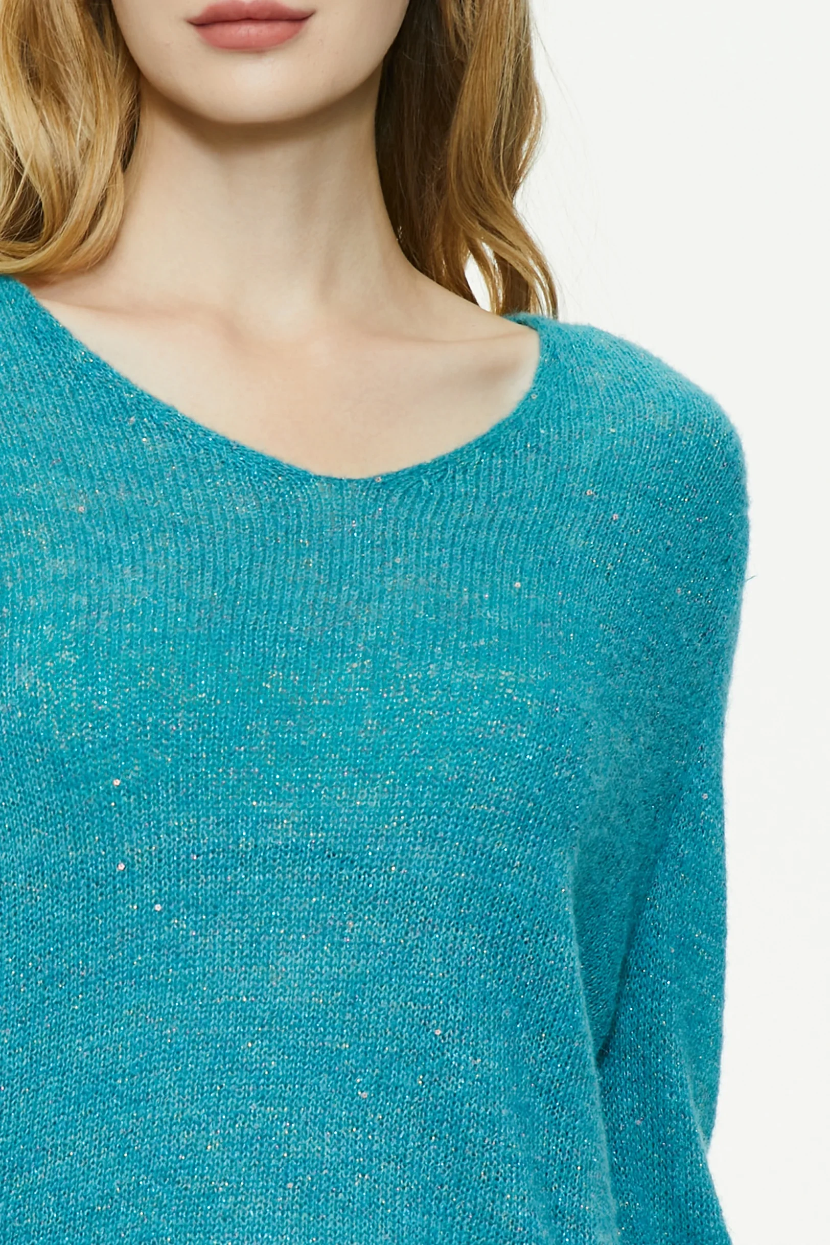 Close-up of a cyan wool blend sweater showing the textured knit fabric