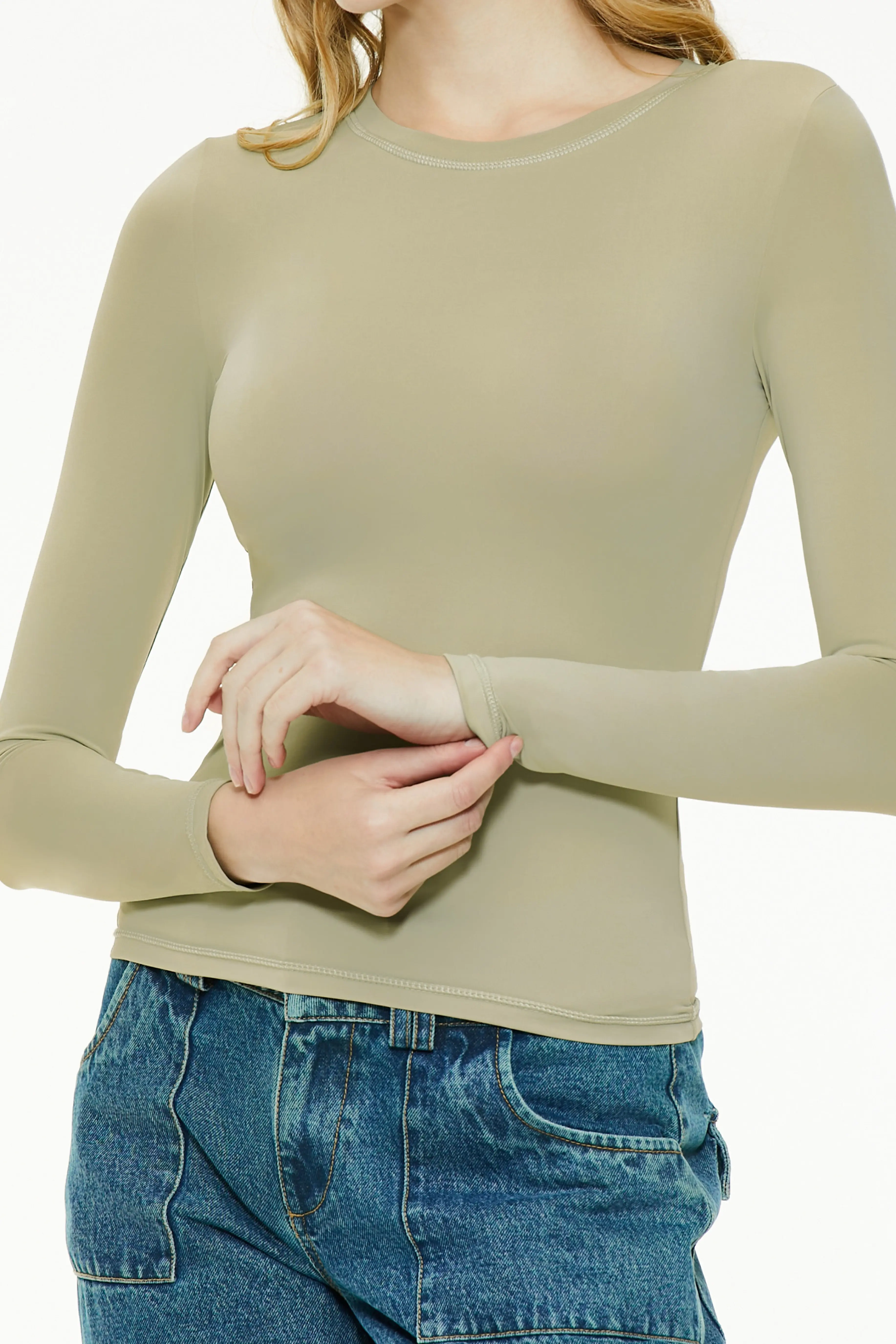 Close-up cuff detail of a light green long sleeve top