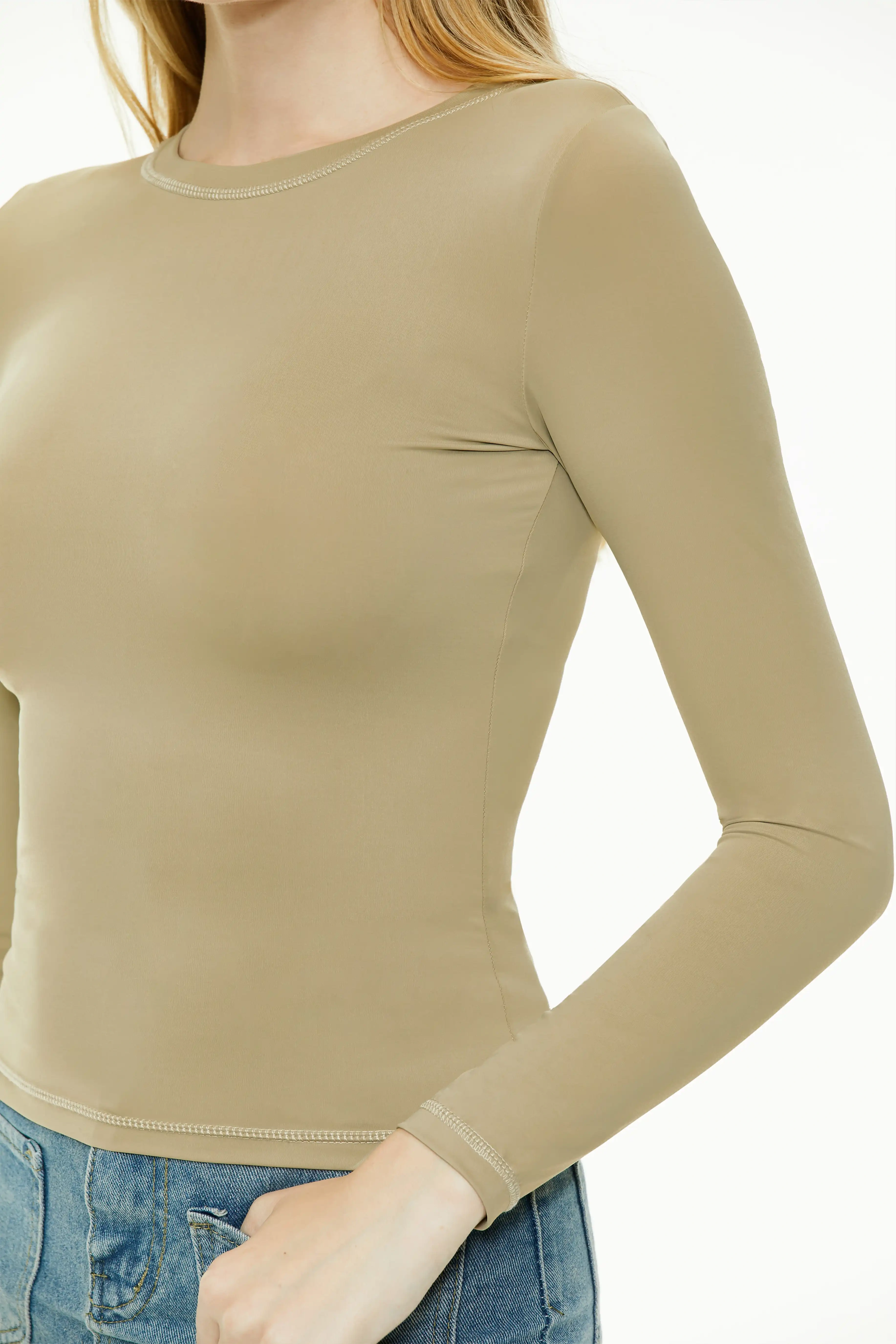Close-up sleeve detail of a khaki green long sleeve top