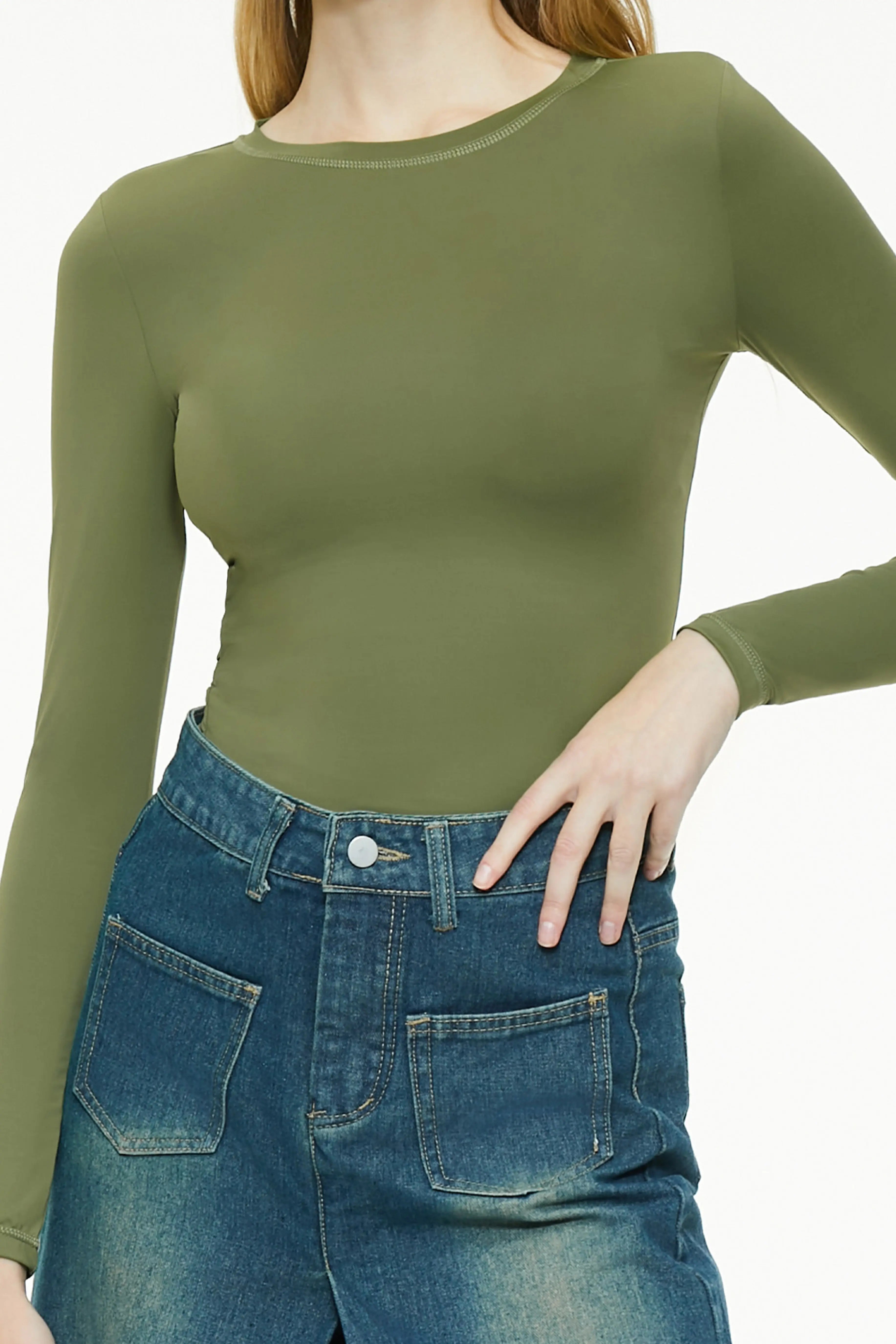 Close-up of a green long sleeve top and utility skirt waist