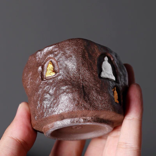 Close-up of the hand-carved arched shrine on The Stone Sanctuary cup; inspired by Dunhuang Grottoes, featuring a mineral gold figure that will mature into an antique bronze luster.