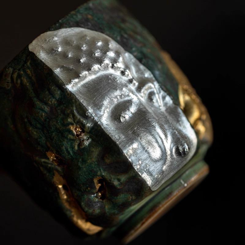 Handmade ceramic cup with silver Buddha face relief and green glaze &mdash; a meaningful mindfulness gift for the spiritual but not religious