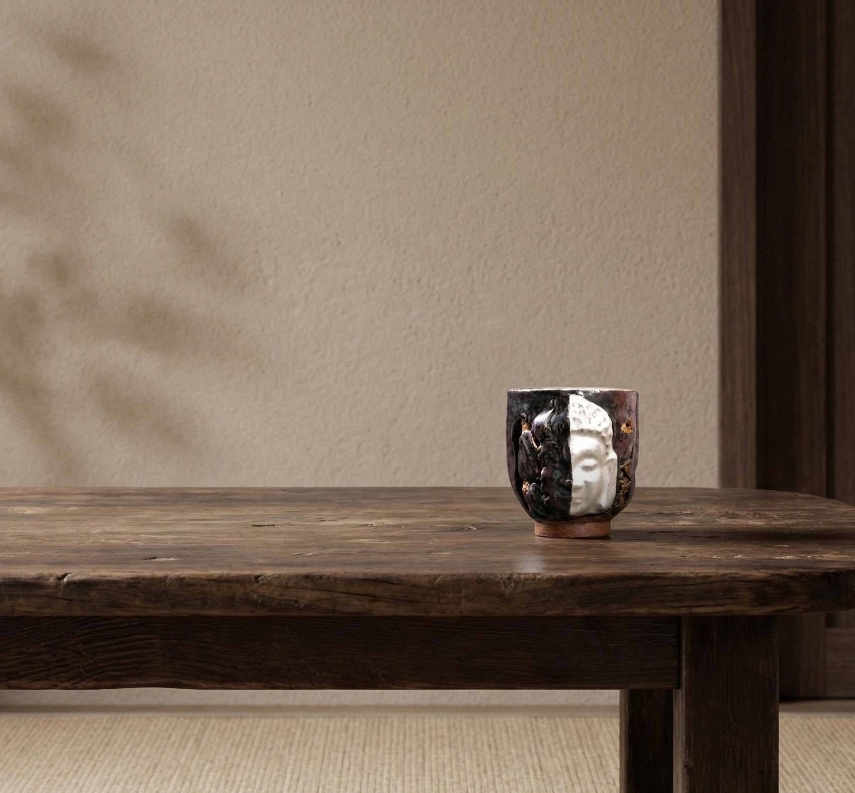 The Duality Insight — handmade ceramic cup with white Buddha face relief on dark glaze, japandi style accessories for a minimalist living space