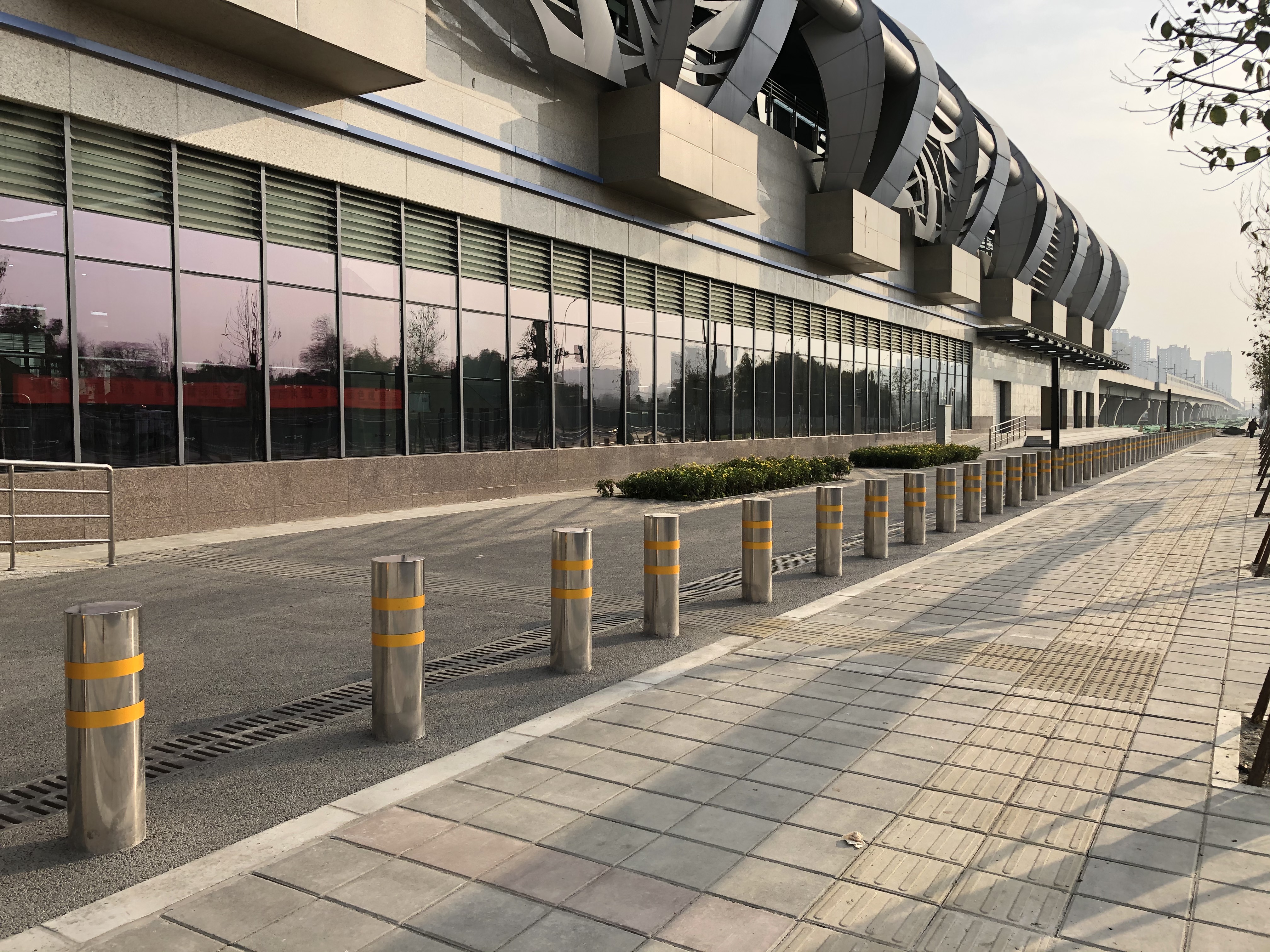 RICJ safety solution: A row of stainless steel bollards illustrating appropriate spacing for perimeter security on a city sidewalk.