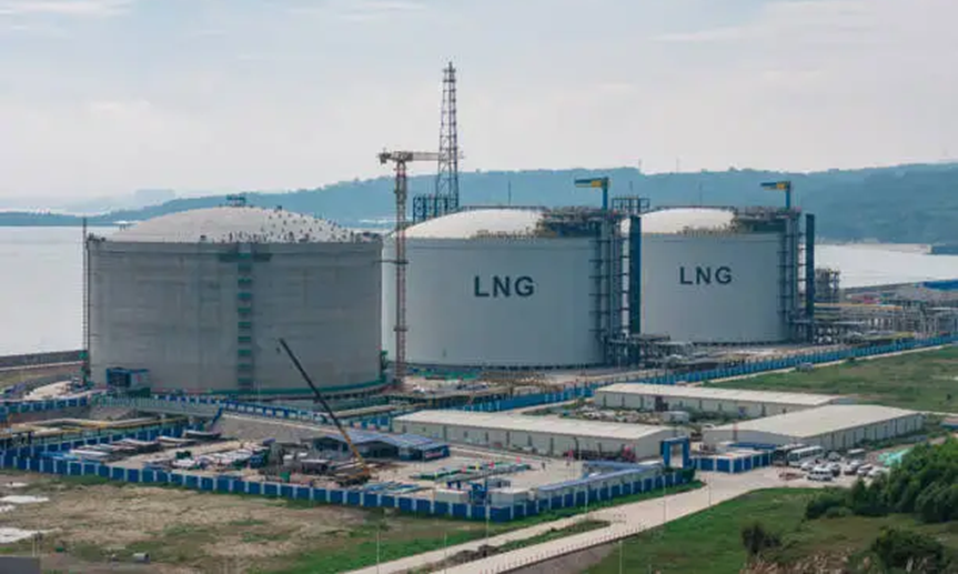 Large LNG carrier vessel transporting liquefied natural gas being escorted by tugboats on the high seas.