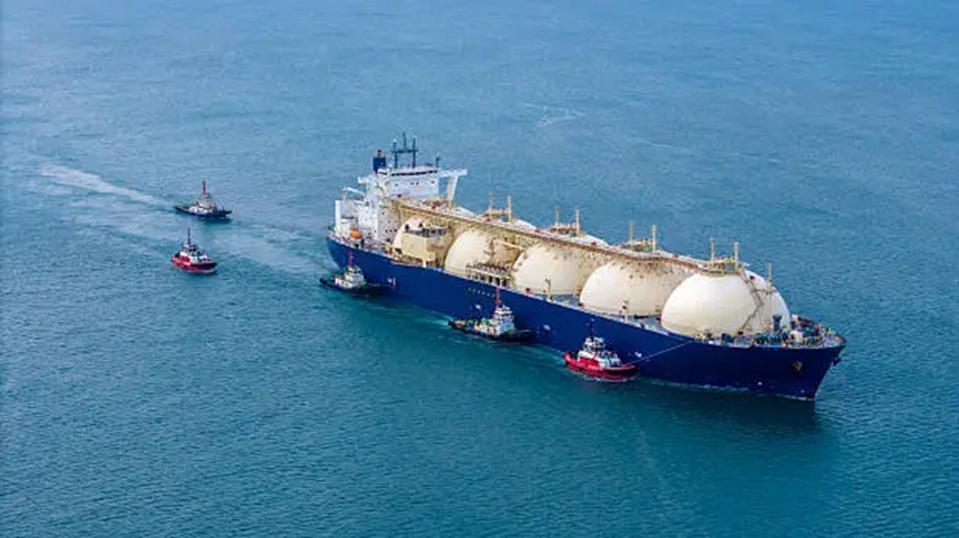 Massive onshore LNG storage tanks at a coastal gas terminal facility under construction.