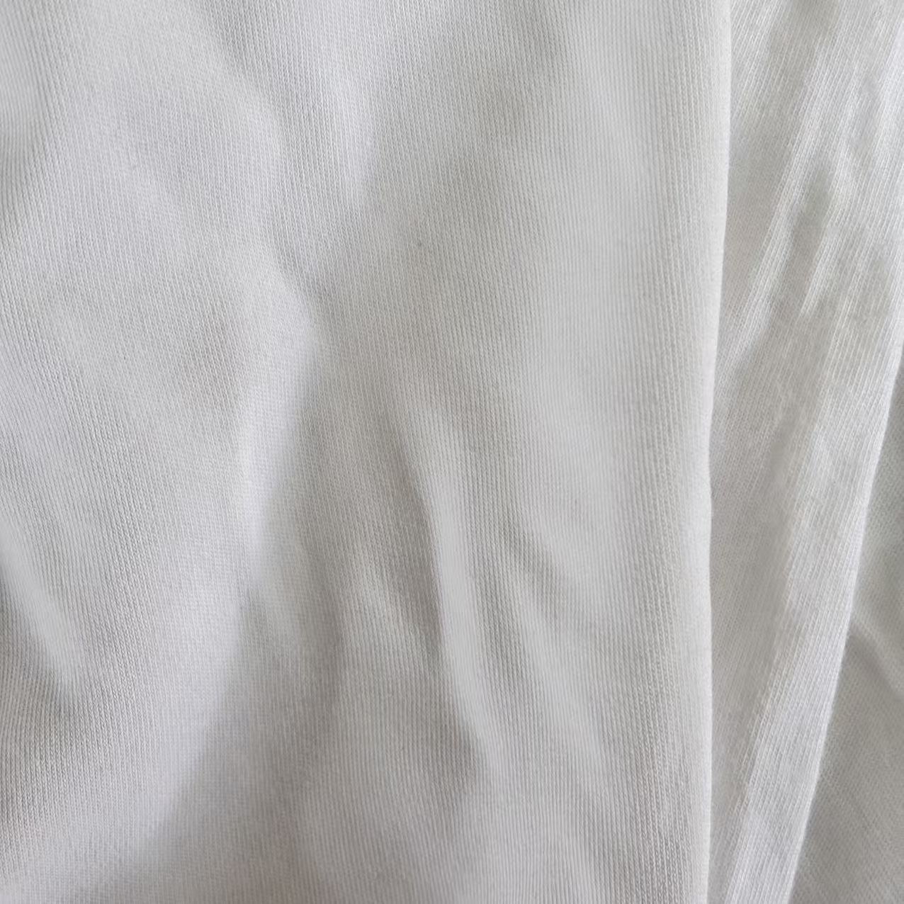 Close-up of Grade A white T-shirt knit rags showing recycled cotton fiber texture, low-lint surface, ideal for precision cleaning tasks.
