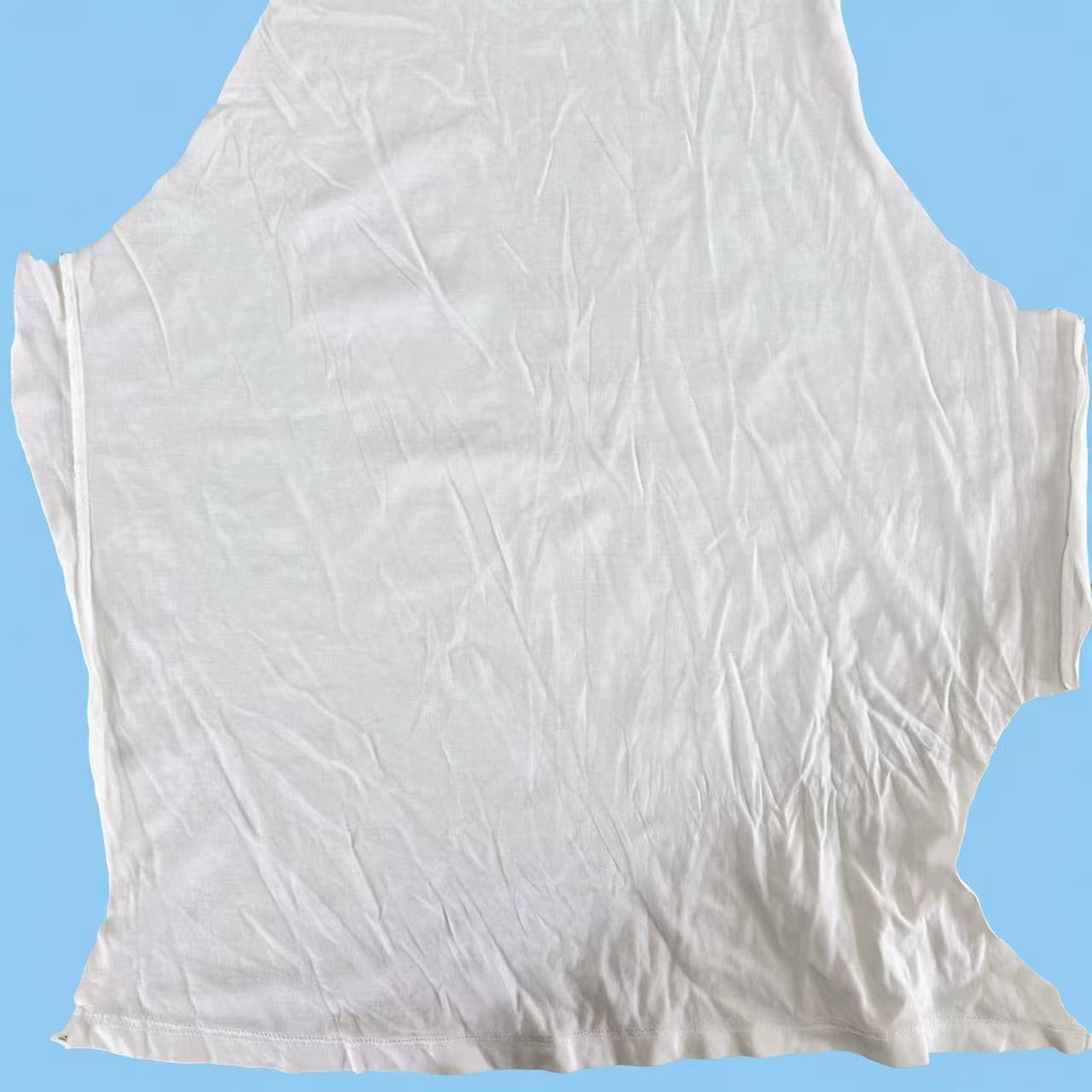 Close-up of Grade B white T-shirt knit rags showing recycled cotton fibers, suitable for everyday industrial wiping tasks.