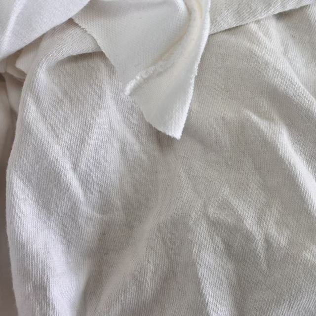 Close-up of Grade B white T-shirt knit rags showing recycled cotton fibers, suitable for everyday industrial wiping tasks.