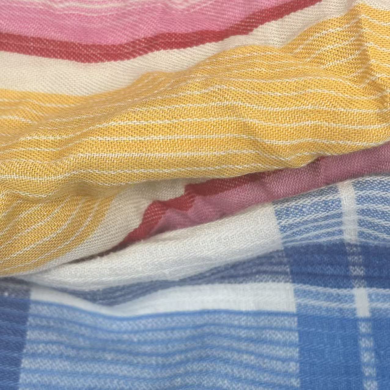 Close-up of mixed colored sheeting rags showing assorted light colors and smooth weave, ideal for versatile cleaning.