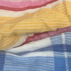 Close-up of mixed colored sheeting rags showing assorted light colors and smooth weave, ideal for versatile cleaning.