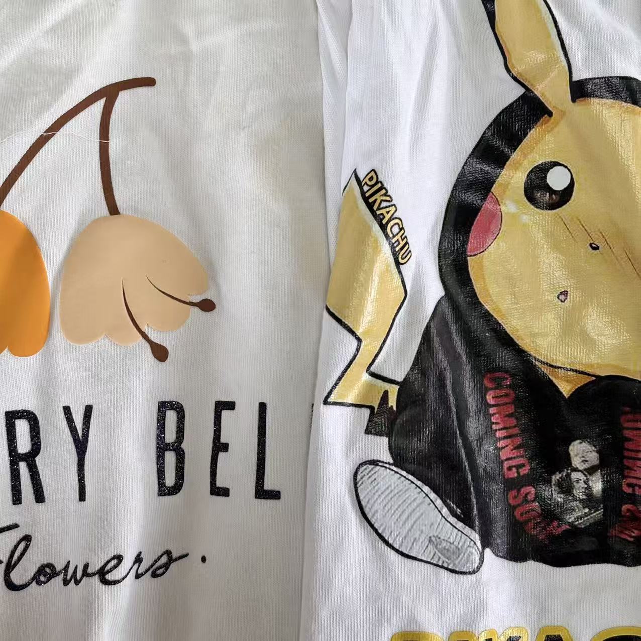 Close-up of printed white T-shirt knit rags showing white background with printed graphics, stain visibility on unprinted areas.