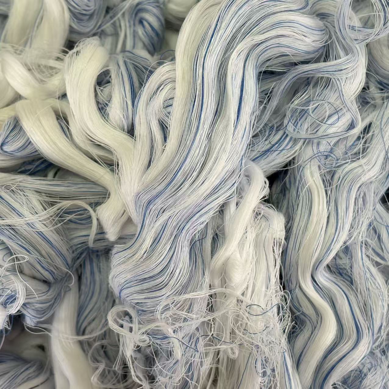 Close-up of colored hand-sorted cotton yarn waste showing dark fiber blend, ideal for heavy oil and grease absorption.
