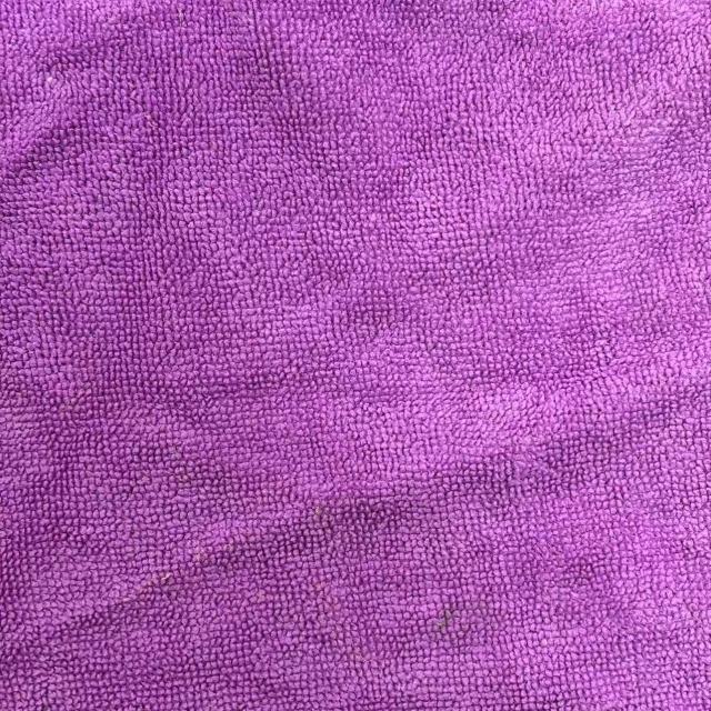 Close-up of colored terry toweling rags showing prominent looped pile texture, high absorbency for heavy oil and coolant.