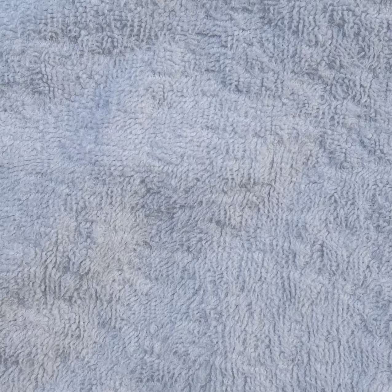 Close-up of Grade A white terry toweling rags showing uniform loops and superior softness for demanding applications.