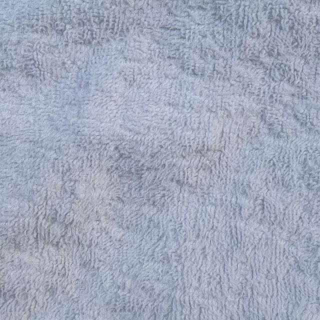 Close-up of Grade A white terry toweling rags showing uniform loops and superior softness for demanding applications.