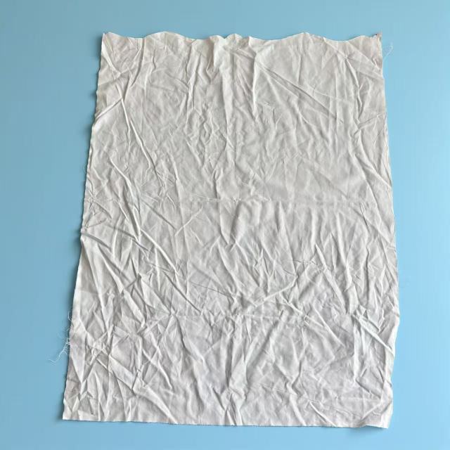 Close-up of premium white sheeting rags showing smooth plain weave, low-lint linen fabric for scratch-free cleaning.
