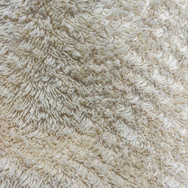 Close-up of uncut colored terry toweling rags showing full towel size and absorbent loop texture.