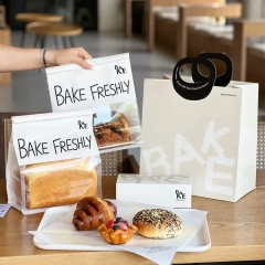 Complete bakery packaging set with printed bread bags, paper carrier bag and pastry box on cafe table
