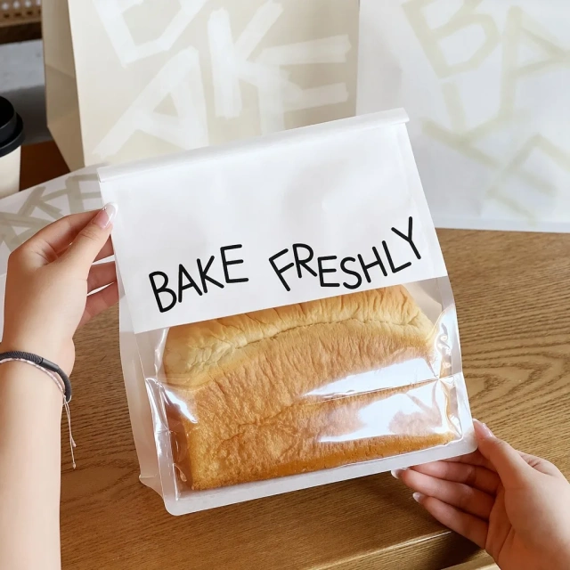 Close-up of flat-bottom toast packaging bag with clear window held in hands