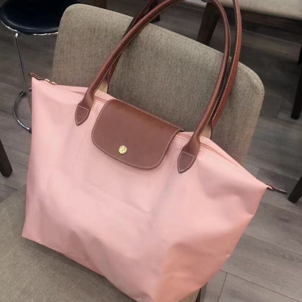 LONGCHAMP medium tote bag with gold hardware, snap buttons, and zipper closure.