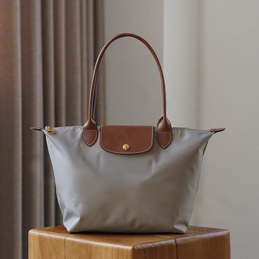 LONGCHAMP medium tote bag with gold hardware, snap buttons, and zipper closure.