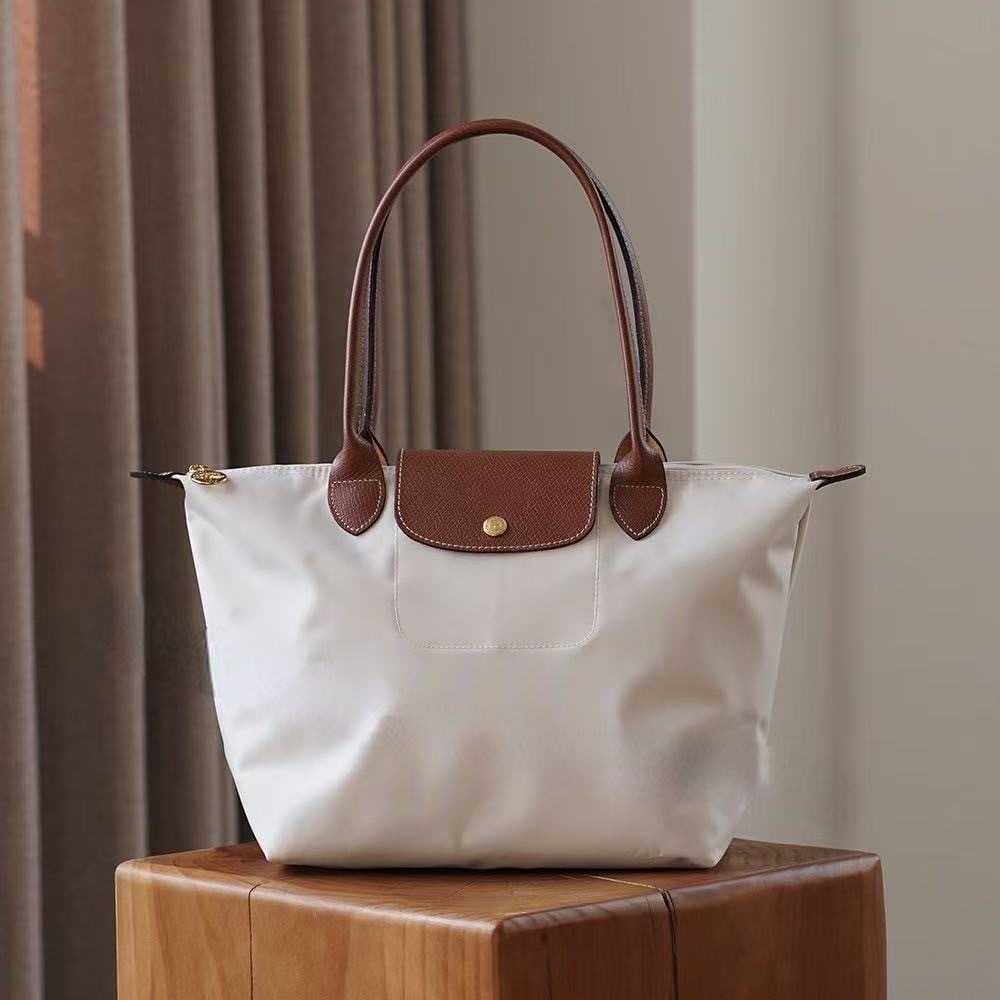 LONGCHAMP medium tote bag with gold hardware, snap buttons, and zipper closure.