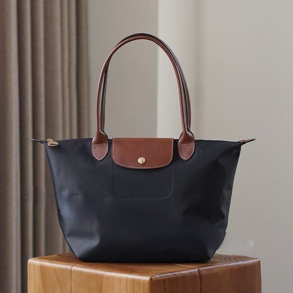 LONGCHAMP medium tote bag with gold hardware, snap buttons, and zipper closure.