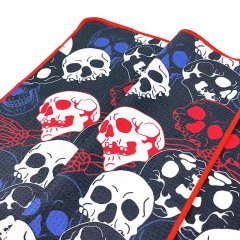 All-over print golf towel with skull pattern and red edge binding
