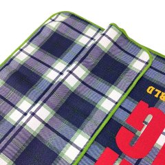 Branded golf towel with bold custom logo on plaid surface