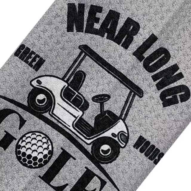 Custom logo golf towel with golf cart graphic on gray surface