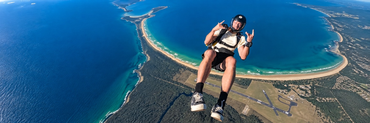Complete skydiver above the Moruya coast, adapted to a wide banner