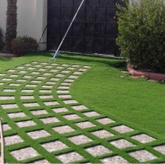 Close-up of UV-resistant artificial grass fibers showing realistic multi-tone thatch.