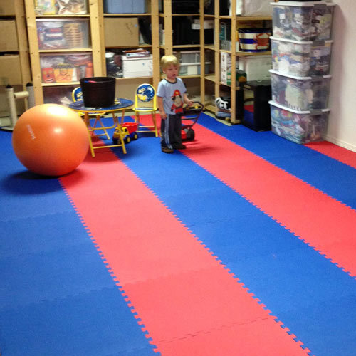 Brightly colored interlocking play mats providing a safe and soft surface in a children's playroom.