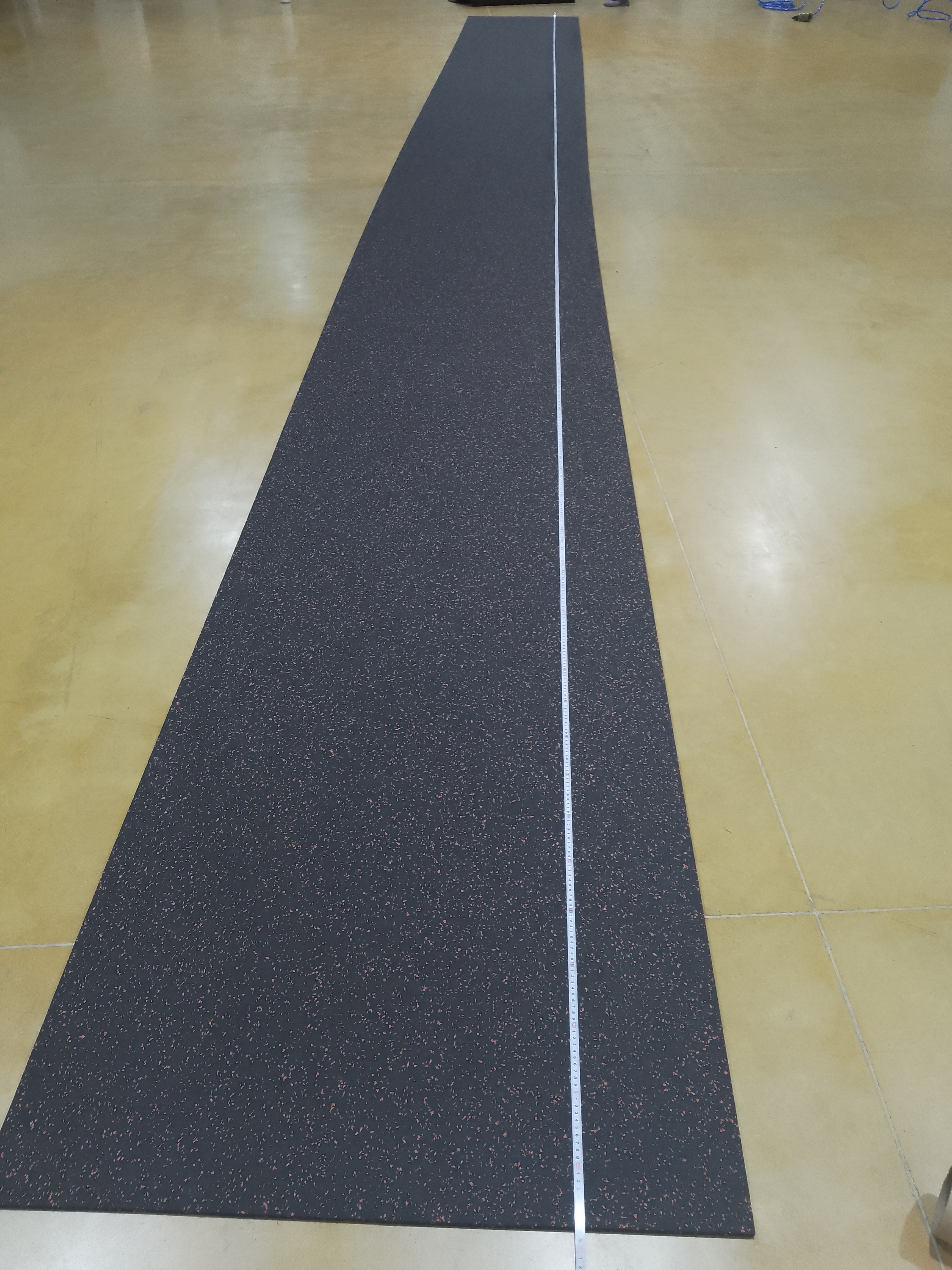 Large-scale installation of professional black rubber rolls in a commercial fitness studio.