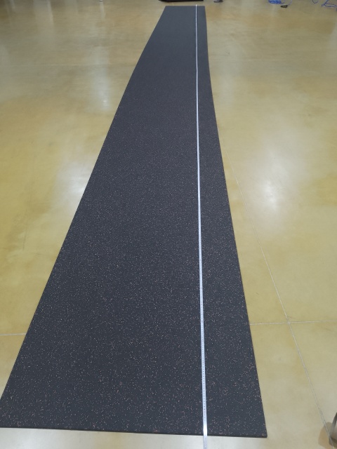 Large-scale installation of professional black rubber rolls in a commercial fitness studio.