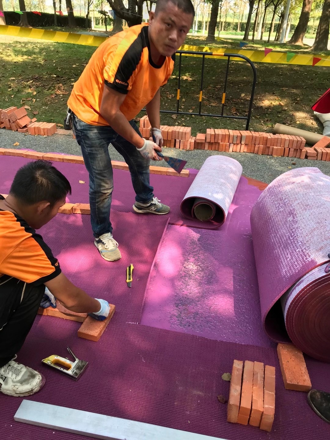 Reusable and relocatable prefabricated rubber track installed in a temporary Olympic stadium.