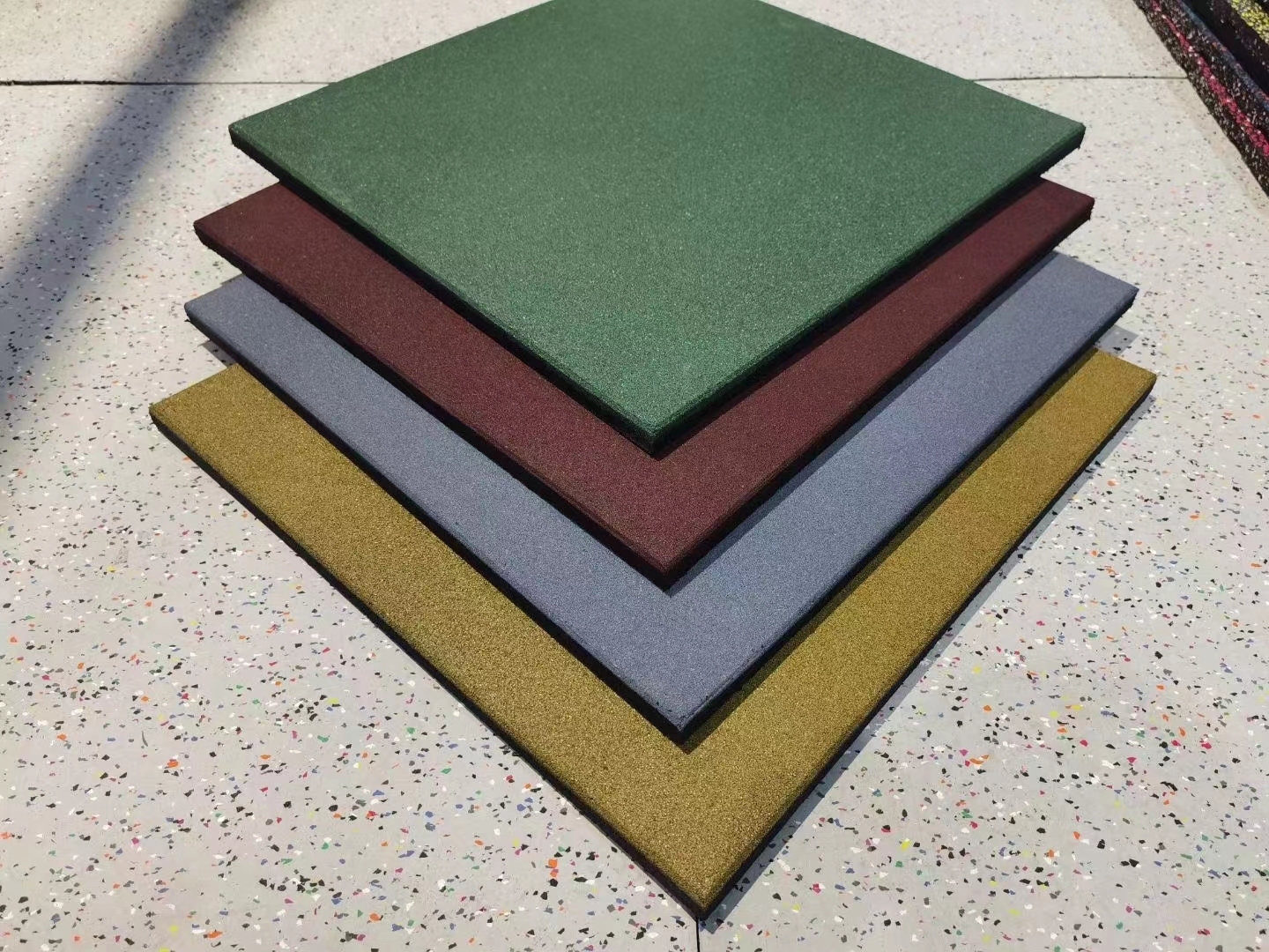Dalles de sécurité en caoutchouc EPDM rouge et vert vif installées dans une aire de jeux pour enfants.