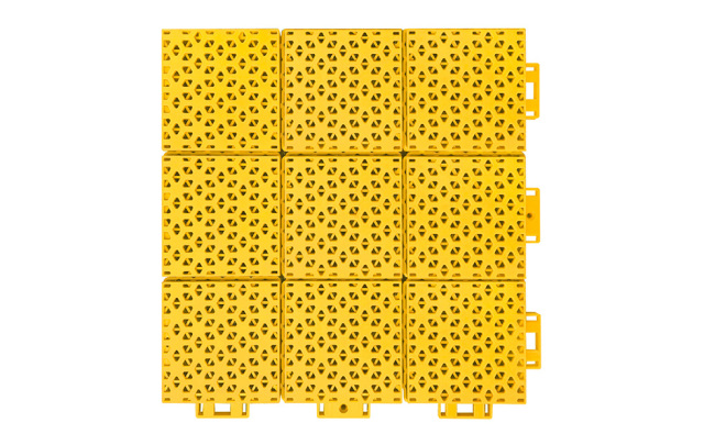 Installed 305×305×16mm double-layer hexagonal polypropylene interlocking playground tiles on an outdoor primary school or kindergarten playground surface, showing full-coverage modular installation, consistent matte-texture surface, and uniform soft-connection joint alignment across the installed area.
