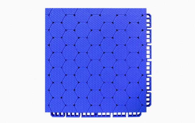 Top-down view of a 250×250×16mm thermoplastic rubber sports flooring tile showing the thickened hexagonal surface pattern in grass green, designed to provide anti-slip traction and wet-surface grip on outdoor school sports courts and municipal fitness facilities.