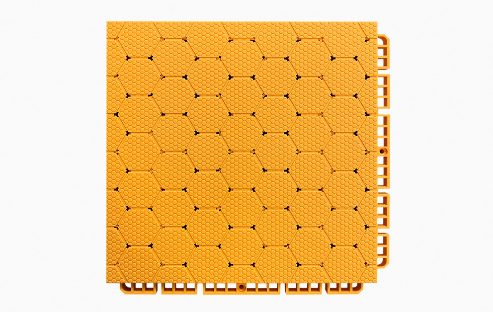 Close-up detail of the dense interlocking connection system between two adjacent thermoplastic rubber sports tiles, showing the perimeter locking geometry that secures panels in planar alignment without adhesive or mechanical fasteners.