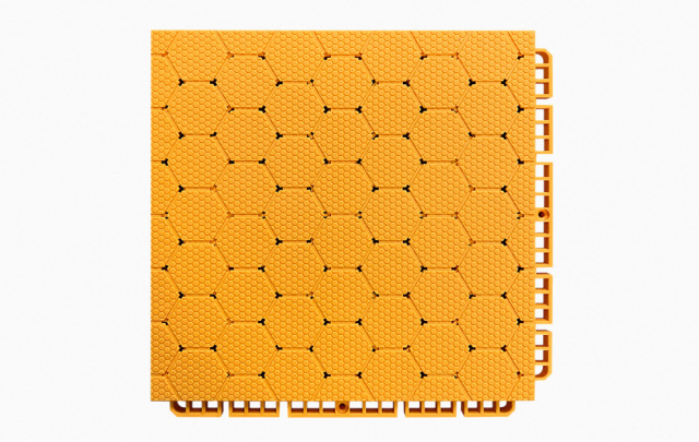 Close-up detail of the dense interlocking connection system between two adjacent thermoplastic rubber sports tiles, showing the perimeter locking geometry that secures panels in planar alignment without adhesive or mechanical fasteners.